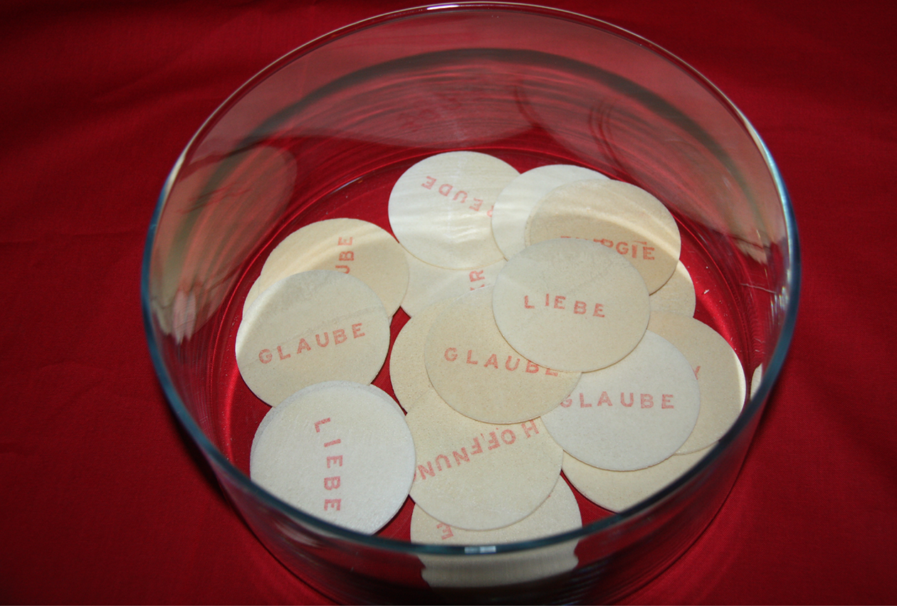 Kreative Intervention im Kirchenraum wurde in der Offenen Sommerkirche 2014 in der Apostel-Paulus-Kirche, Berlin-Schöneberg, Oblaten, "Abendmahl to go" mit Aufdruck: Glaube, Liebe, Hoffnung